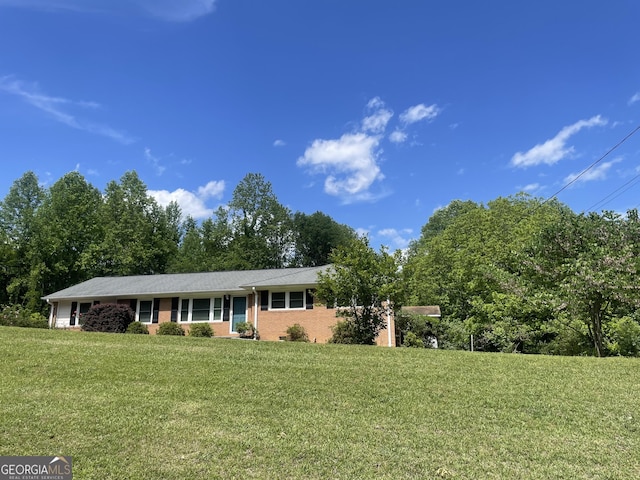 ranch-style home with a front yard and brick siding
