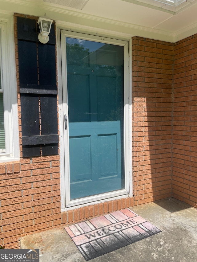 property entrance featuring brick siding
