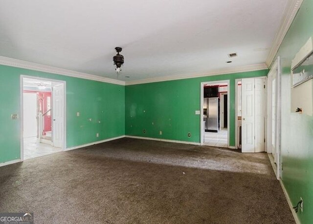 spare room with carpet flooring, crown molding, and baseboards