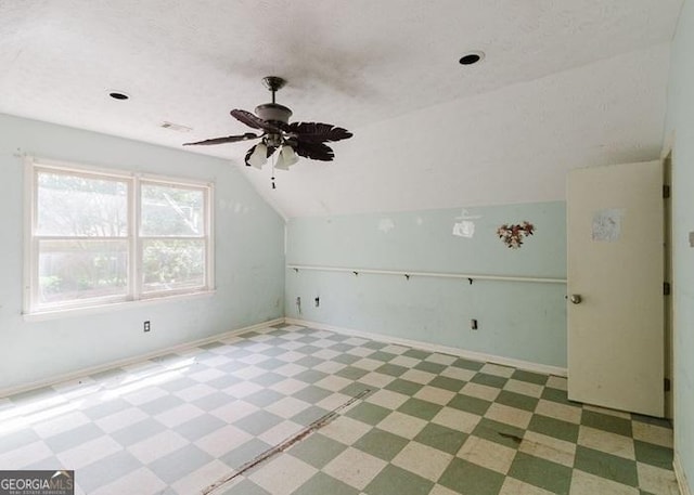 bonus room featuring vaulted ceiling, light flooring, ceiling fan, and baseboards