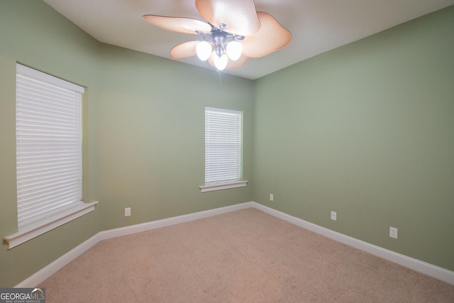 spare room featuring carpet floors, ceiling fan, and baseboards
