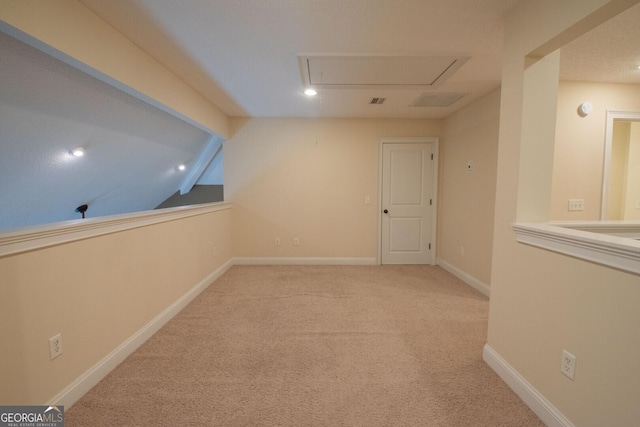 corridor featuring attic access, carpet, vaulted ceiling, recessed lighting, and baseboards