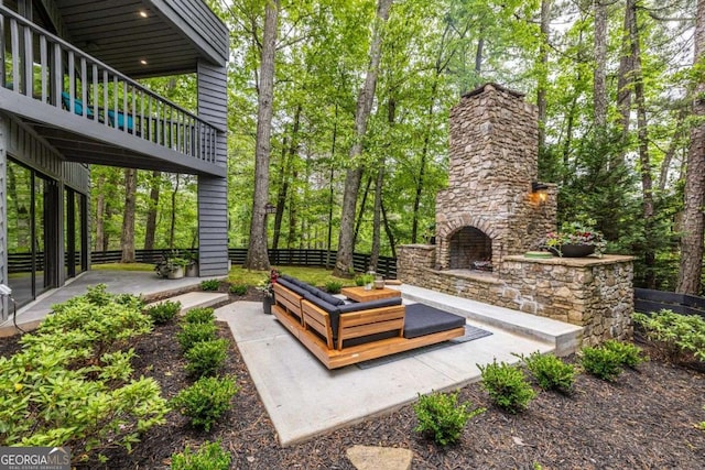 view of patio featuring an outdoor stone fireplace and fence