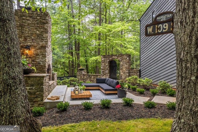 view of yard featuring an outdoor living space with a fireplace