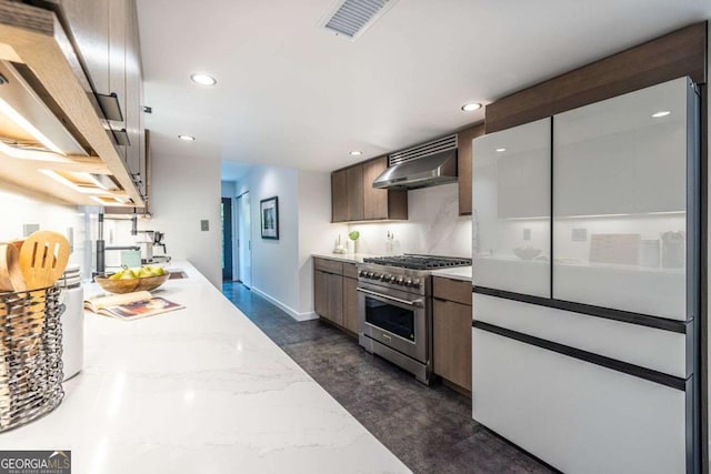 kitchen with high end range, range hood, recessed lighting, baseboards, and light stone countertops