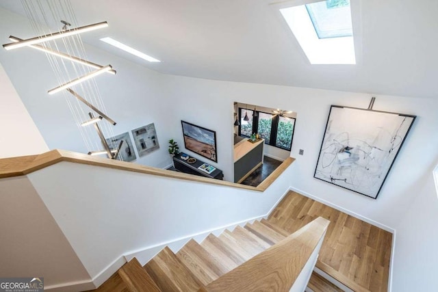 stairway featuring a skylight and wood finished floors