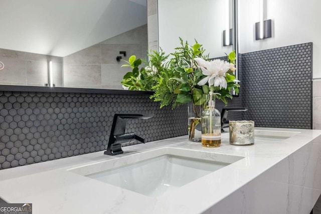 bathroom featuring double vanity and lofted ceiling