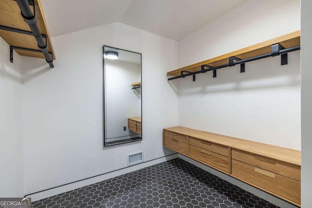 walk in closet with dark floors