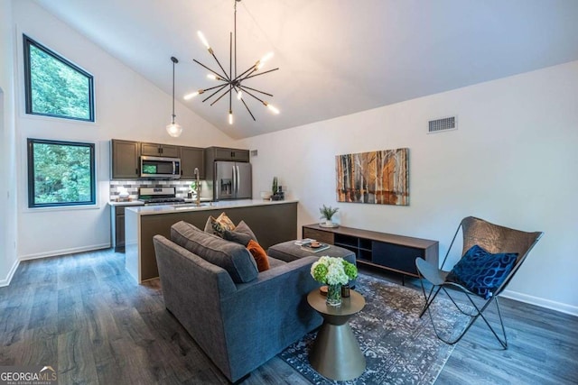 living area with a chandelier, dark wood finished floors, baseboards, and high vaulted ceiling