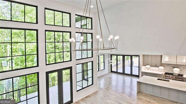 2346 E Maddox Rd, Buford, GA 30518 - doorway to outside with french doors, a high ceiling, light wood-style floors, a sink, and a chandelier