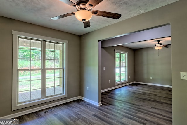 unfurnished room with a ceiling fan, baseboards, and dark wood finished floors