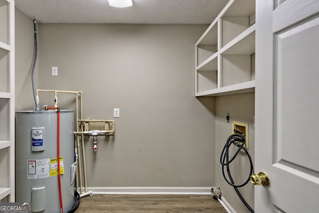 washroom with water heater, electric dryer hookup, wood finished floors, hookup for a washing machine, and baseboards