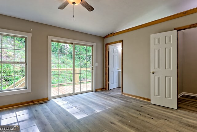 doorway to outside with vaulted ceiling, baseboards, a ceiling fan, and plenty of natural light