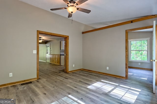 spare room featuring ceiling fan, baseboards, and wood finished floors