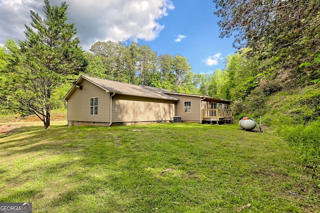 back of house featuring a lawn and a deck