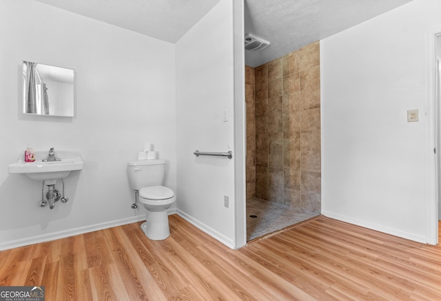144 Bryant Rd, Cordele, GA 31015 - bathroom with a tile shower, toilet, wood finished floors, and baseboards