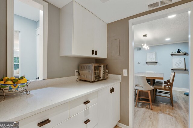 6851 Roswell Rd Unit K-23, Atlanta, GA 30328 - kitchen featuring white cabinets, light wood finished floors, baseboards, recessed lighting, and light stone counters