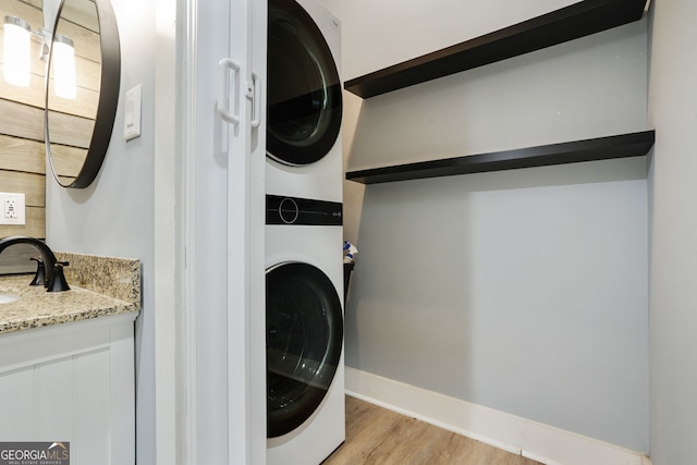 6851 Roswell Rd Unit K-23, Atlanta, GA 30328 - washroom with stacked washer and clothes dryer, light wood-type flooring, and baseboards