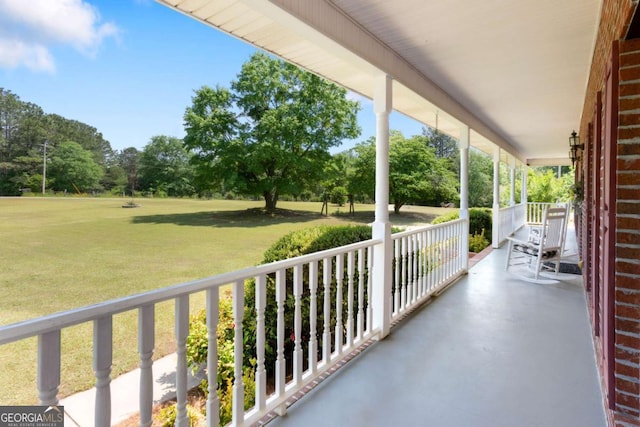 balcony featuring a porch and view of wooded area