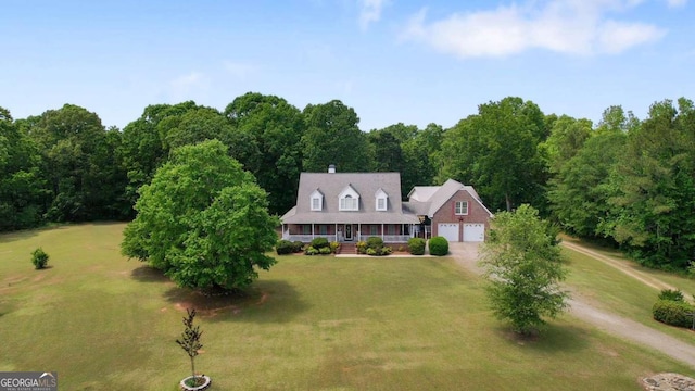 view of front facade with covered porch, a front yard, a garage, and driveway