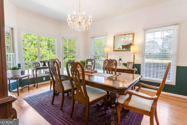 dining area featuring a chandelier, crown molding, wood finished floors, and baseboards
