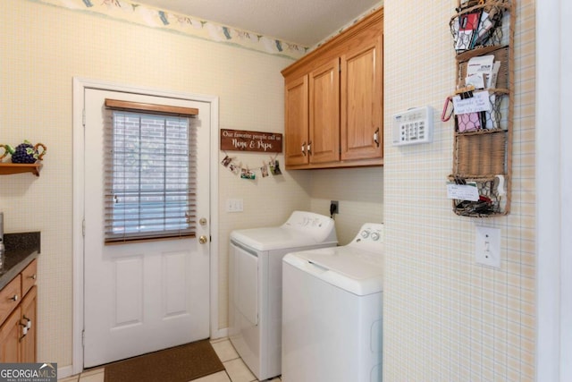 laundry room with cabinet space, washing machine and clothes dryer, and light tile patterned floors