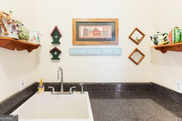 kitchen with open shelves, a sink, tile walls, and dark countertops