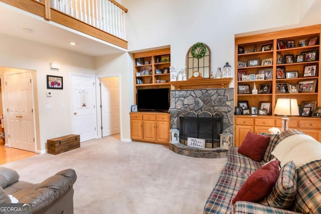carpeted living area with a high ceiling, a fireplace, and baseboards