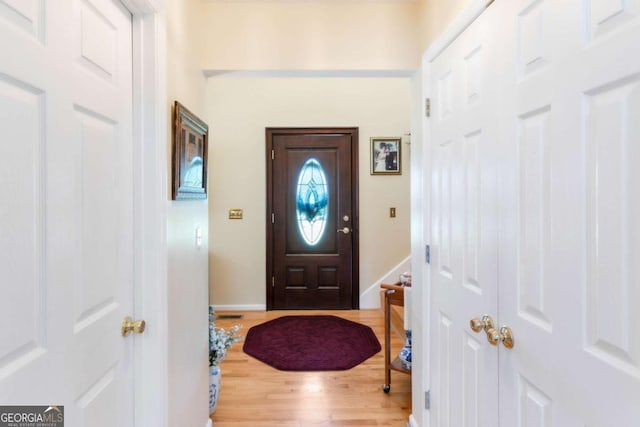 foyer entrance with wood finished floors and baseboards