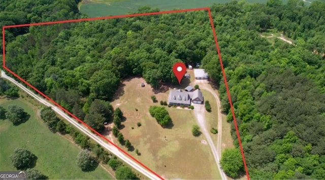 aerial overview of property's location featuring property boundaries highlighted and a heavily wooded area