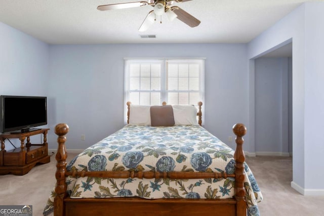 bedroom featuring light carpet, baseboards, and a ceiling fan