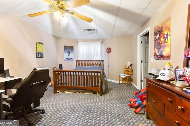 bedroom featuring a drop ceiling, carpet floors, a desk, baseboards, and a ceiling fan