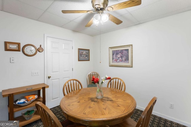 dining room featuring a drop ceiling, ceiling fan, and baseboards