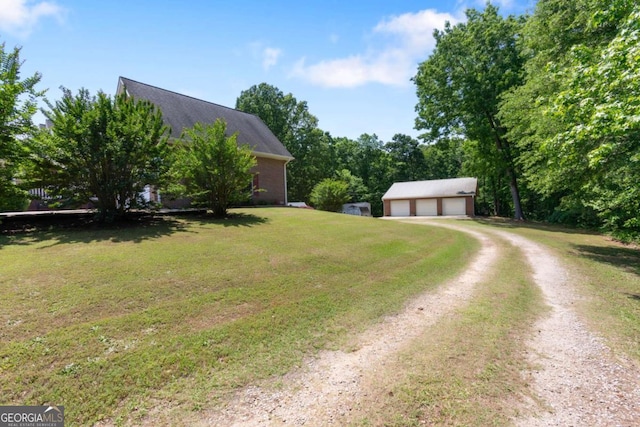 view of front of home with a garage, an outdoor structure, a front lawn, driveway, and roof with shingles