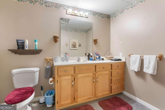 bathroom with baseboards, vanity, and toilet