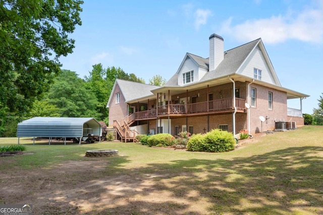 back of property with a lawn, a carport, brick siding, a chimney, and a wooden deck