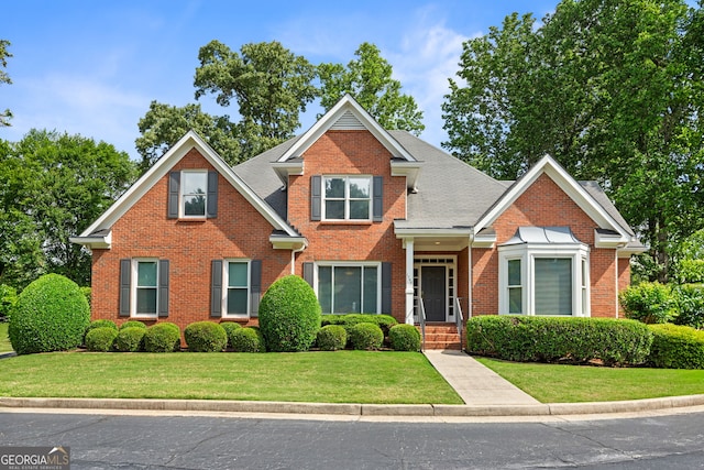 view of front of property with brick siding and a front yard