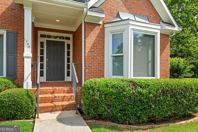 entrance to property featuring brick siding