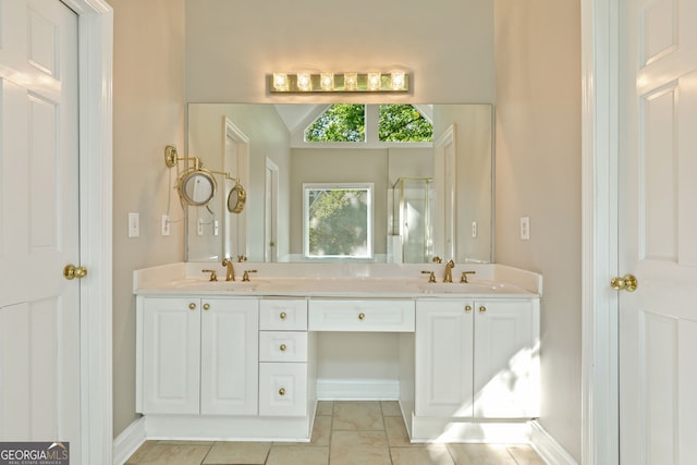 full bathroom with double vanity, a stall shower, baseboards, and tile patterned floors