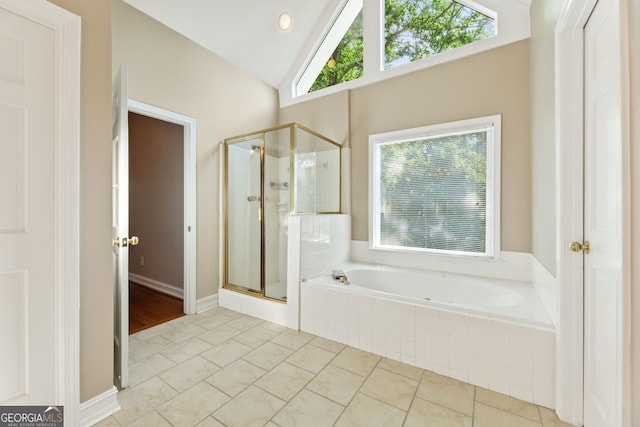 bathroom featuring a stall shower, a bath, vaulted ceiling, and tile patterned flooring
