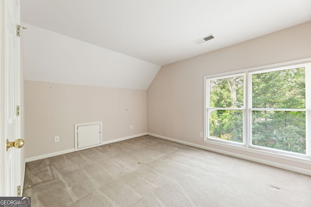 bonus room featuring light carpet, vaulted ceiling, and baseboards