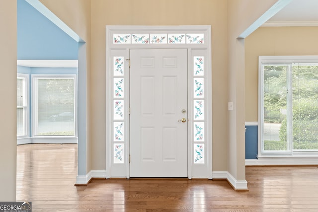 entrance foyer with hardwood / wood-style flooring, baseboards, and ornamental molding