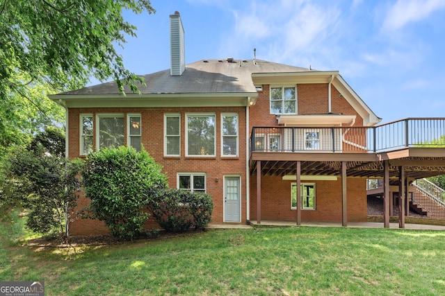 back of house with brick siding, a chimney, a yard, a wooden deck, and stairs