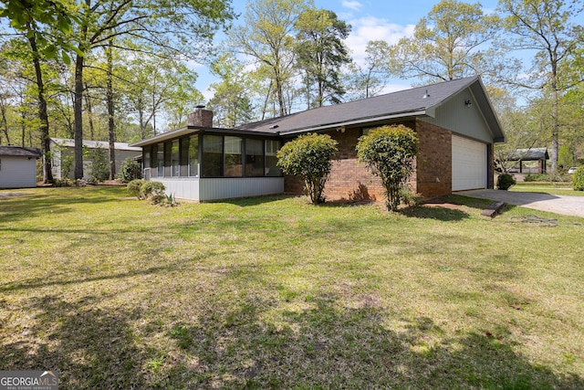 182 Quail Hollow Ln, Fort Valley, GA 31030 - view of property exterior with a sunroom, driveway, a chimney, a lawn, and a garage