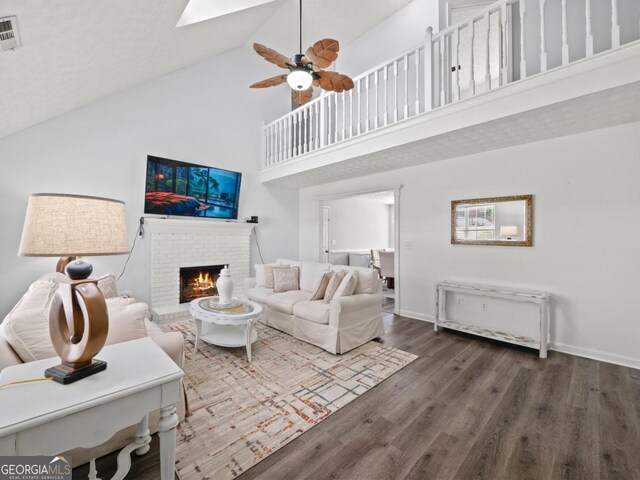 5293 Hopewell Ln, Gainesville, GA 30507 - living area with high vaulted ceiling, a brick fireplace, wood finished floors, ceiling fan, and baseboards