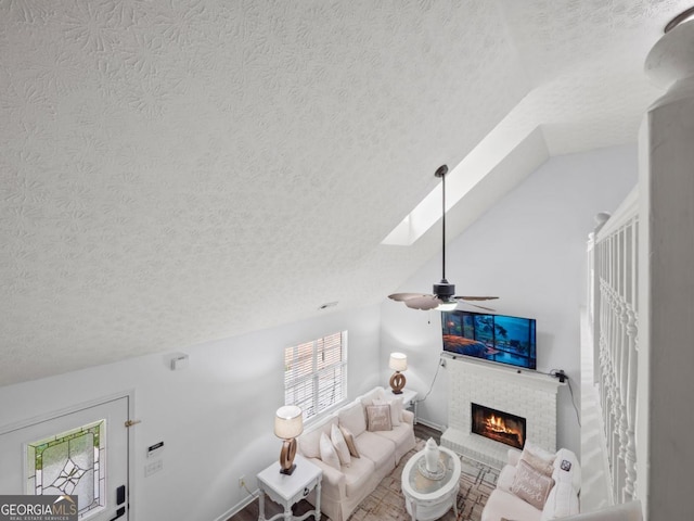 5293 Hopewell Ln, Gainesville, GA 30507 - living room featuring a textured ceiling, a skylight, a brick fireplace, lofted ceiling, and ceiling fan