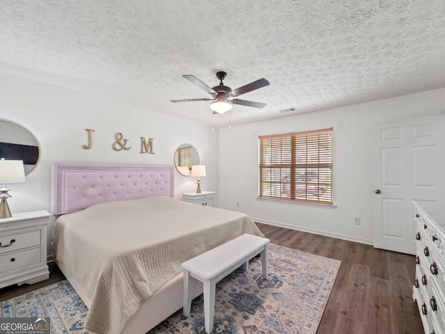 5293 Hopewell Ln, Gainesville, GA 30507 - bedroom featuring dark wood finished floors, a textured ceiling, a ceiling fan, and baseboards