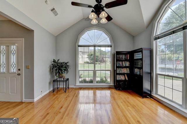 foyer featuring a ceiling fan, healthy amount of natural light, wood finished floors, and vaulted ceiling