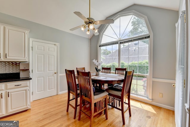 dining area with lofted ceiling, healthy amount of natural light, light wood finished floors, ceiling fan, and baseboards