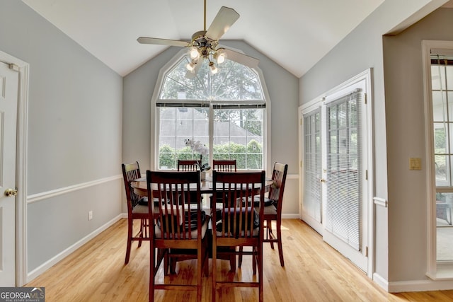 dining space with light wood-style flooring, ceiling fan, vaulted ceiling, and baseboards